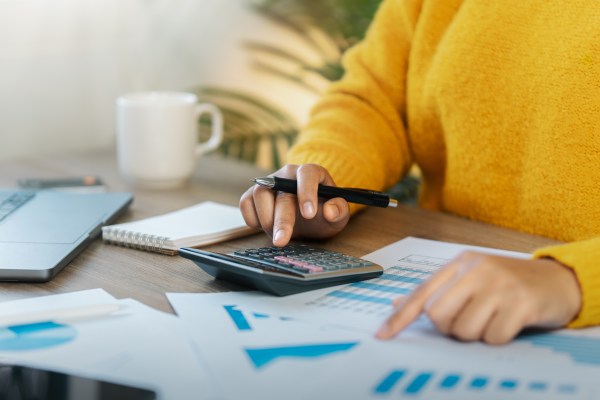 Businesswoman Accounting, Calculating income-expenses and analyzing investment data reports. Annual tax reduction planning concept, financial and tax systems.